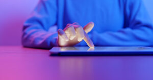 A finger taps on a tablet computer screen
