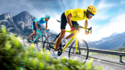 two sports people on bikes racing on a road, one is gaining an advantage